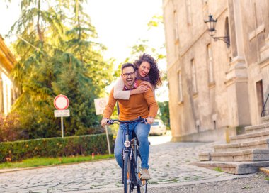 Mutlu çift şehirde güneşli bir sonbahar gününde bisiklet sürerken eğleniyor..
