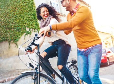 Mutlu çift şehirde güneşli bir sonbahar gününde bisiklet sürerken eğleniyor..