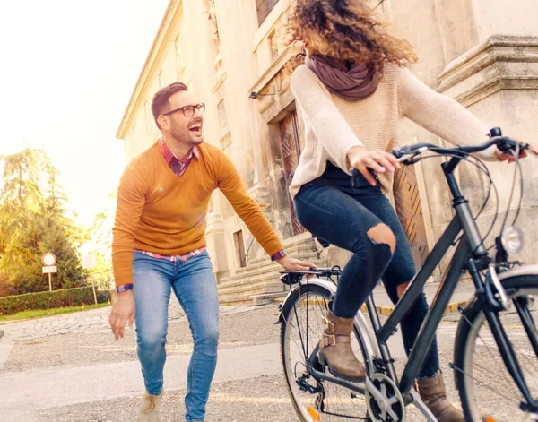 Mutlu çift şehirde güneşli bir sonbahar gününde bisiklet sürerken eğleniyor..