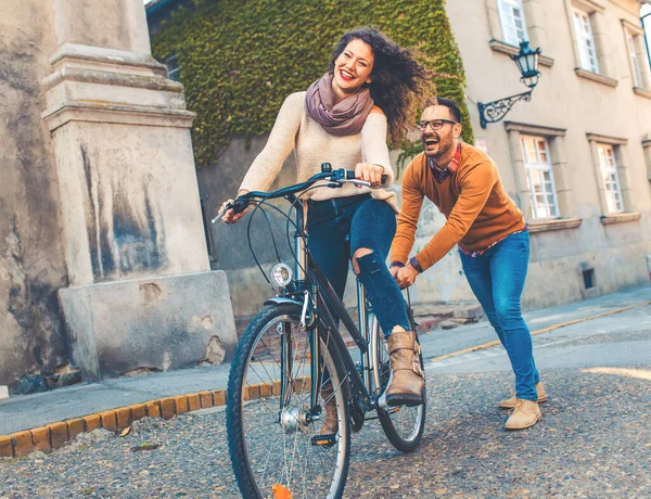 Mutlu çift şehirde güneşli bir sonbahar gününde bisiklet sürerken eğleniyor..