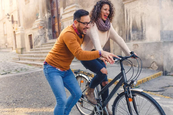Mutlu çift şehirde güneşli bir sonbahar gününde bisiklet sürerken eğleniyor..