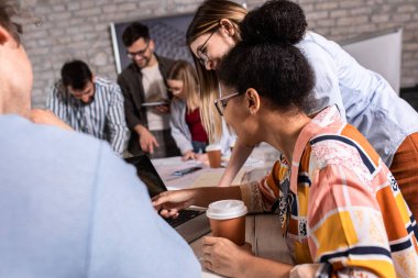 Modern iş adamlarından oluşan bir grup, yaratıcı ofiste mimari tasarımları tartışıyor..