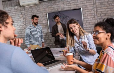 Modern iş adamlarından oluşan bir grup, yaratıcı ofiste mimari tasarımları tartışıyor..