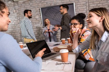 Modern iş adamlarından oluşan bir grup, yaratıcı ofiste mimari tasarımları tartışıyor..