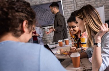 Modern iş adamlarından oluşan bir grup, yaratıcı ofiste mimari tasarımları tartışıyor..