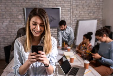 Genç bayan liderin portresi ofiste duruyor ve telefona bakıyor..