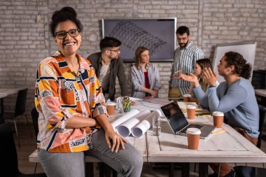Ofiste durmuş kameraya bakan genç bir kadın liderin portresi..