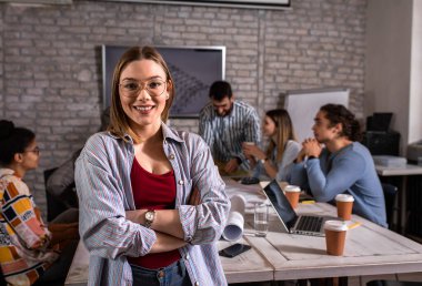 Ofiste durmuş kameraya bakan genç bir kadın liderin portresi..