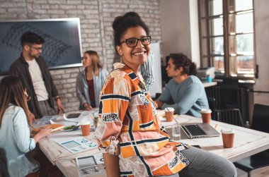 Ofiste durmuş kameraya bakan genç bir kadın liderin portresi..