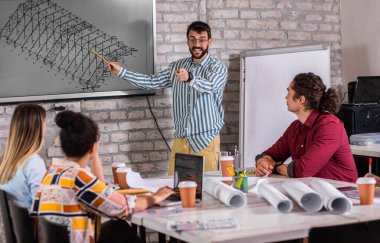 Modern iş adamlarından oluşan bir grup, yaratıcı ofiste mimari tasarımları tartışıyor..