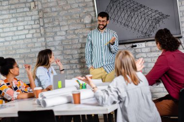 Modern iş adamlarından oluşan bir grup, yaratıcı ofiste mimari tasarımları tartışıyor..