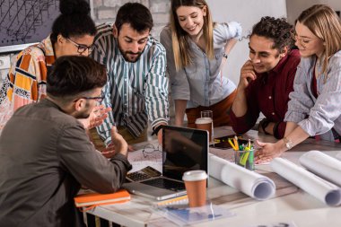 Modern iş adamlarından oluşan bir grup, yaratıcı ofiste mimari tasarımları tartışıyor..