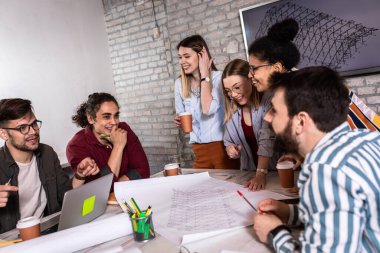 Modern iş adamlarından oluşan bir grup, yaratıcı ofiste mimari tasarımları tartışıyor..