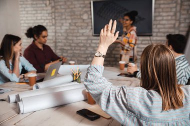 Modern iş adamlarından oluşan bir grup, yaratıcı ofiste mimari tasarımları tartışıyor..