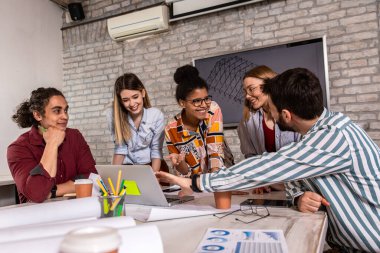 Modern iş adamlarından oluşan bir grup, yaratıcı ofiste mimari tasarımları tartışıyor..