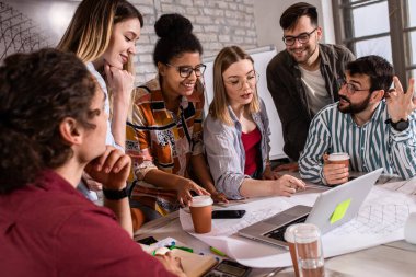 Modern iş adamlarından oluşan bir grup, yaratıcı ofiste mimari tasarımları tartışıyor..