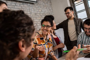 Modern iş adamlarından oluşan bir grup, yaratıcı ofiste mimari tasarımları tartışıyor..