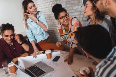 Modern iş adamlarından oluşan bir grup, yaratıcı ofiste mimari tasarımları tartışıyor..