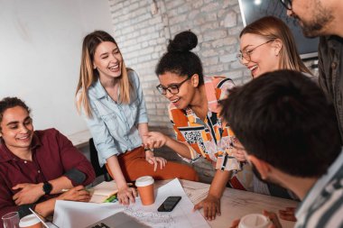 Modern iş adamlarından oluşan bir grup, yaratıcı ofiste mimari tasarımları tartışıyor..