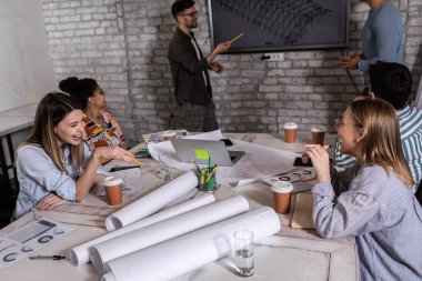 Modern iş adamlarından oluşan bir grup, yaratıcı ofiste mimari tasarımları tartışıyor..