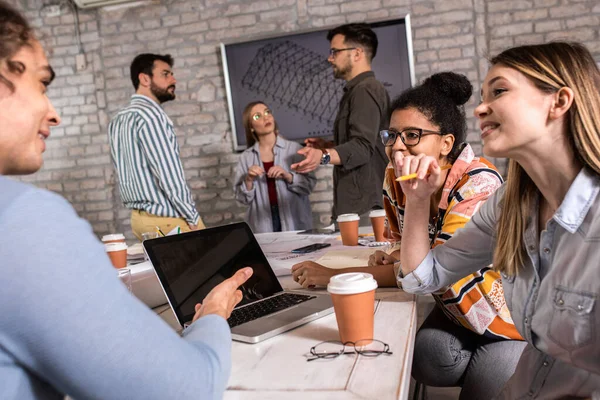 Modern iş adamlarından oluşan bir grup, yaratıcı ofiste mimari tasarımları tartışıyor..