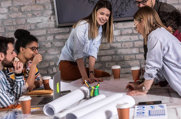 Modern iş adamlarından oluşan bir grup, yaratıcı ofiste mimari tasarımları tartışıyor..