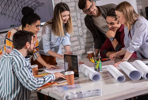 Modern iş adamlarından oluşan bir grup, yaratıcı ofiste mimari tasarımları tartışıyor..