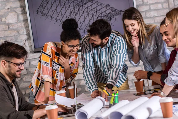 Modern iş adamlarından oluşan bir grup, yaratıcı ofiste mimari tasarımları tartışıyor..