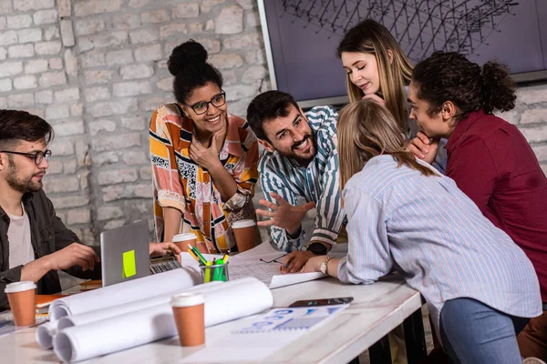 Modern iş adamlarından oluşan bir grup, yaratıcı ofiste mimari tasarımları tartışıyor..