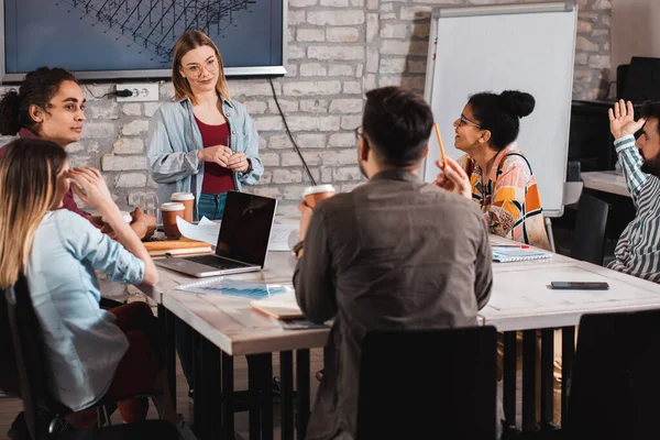 Modern iş adamlarından oluşan bir grup, yaratıcı ofiste mimari tasarımları tartışıyor..