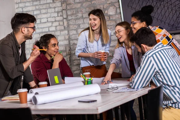 Modern iş adamlarından oluşan bir grup, yaratıcı ofiste mimari tasarımları tartışıyor..