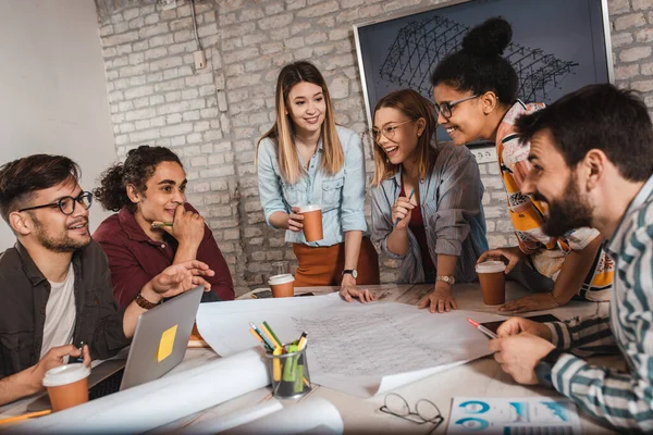 Modern iş adamlarından oluşan bir grup, yaratıcı ofiste mimari tasarımları tartışıyor..