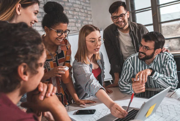 Modern iş adamlarından oluşan bir grup, yaratıcı ofiste mimari tasarımları tartışıyor..