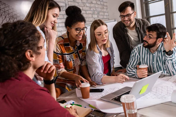 Modern iş adamlarından oluşan bir grup, yaratıcı ofiste mimari tasarımları tartışıyor..