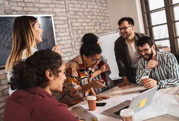 Modern iş adamlarından oluşan bir grup, yaratıcı ofiste mimari tasarımları tartışıyor..