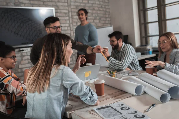 Modern iş adamlarından oluşan bir grup, yaratıcı ofiste mimari tasarımları tartışıyor..