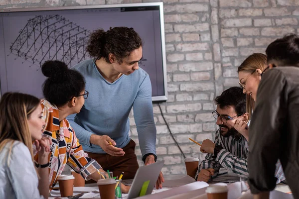 Modern iş adamlarından oluşan bir grup, yaratıcı ofiste mimari tasarımları tartışıyor..