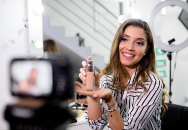 Genç bayan blogcu güzellik blogu için kozmetik üzerine bir video hazırlıyor.