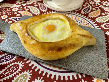 Renkli bir masa örtüsü üzerinde geleneksel Gürcü mayalanmış ekmeği.