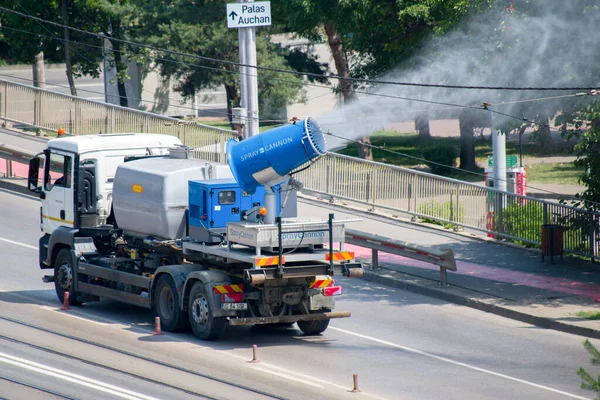 Şehir caddesi, Iasi, Romanya 'da kirlilik önleyici su püskürtme kamyonu. Sis tabancası ya da toz önleyici kamyonlar, PM2.5 ve PM10 gibi havadaki partikül maddeleri azaltmak için ultra ince bir su püskürterek çalışır..