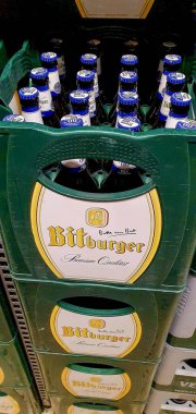 Bitburger bira şişeleri bir süpermarkette, seçici odaklı. Bitburger, klasik pilsner ve ikonik sloganı 