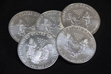 Bir ons Amerikan Kartalı gümüş sikkesi yığını, seçici odak noktası. Amerikan Gümüş Kartalı, Birleşik Devletler 'in ağırlığı ve ağırlığı için ABD hükümeti tarafından garanti edilen 1 ons gümüş külçe sikkesidir. 9 saflık.