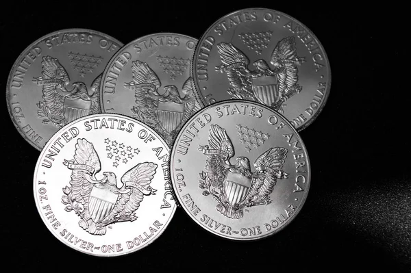 Bir ons Amerikan Kartalı gümüş sikkesi yığını, seçici odak noktası. Amerikan Gümüş Kartalı, Birleşik Devletler 'in ağırlığı ve ağırlığı için ABD hükümeti tarafından garanti edilen 1 ons gümüş külçe sikkesidir. 9 saflık.