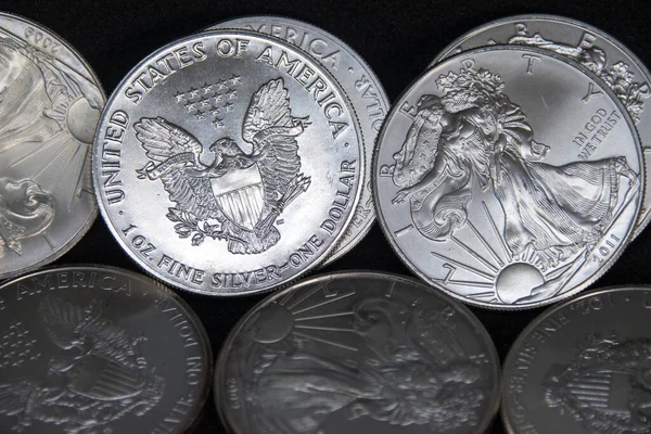 Bir ons Amerikan Kartalı gümüş sikkesi yığını, seçici odak noktası. Amerikan Gümüş Kartalı, Birleşik Devletler 'in ağırlığı ve ağırlığı için ABD hükümeti tarafından garanti edilen 1 ons gümüş külçe sikkesidir. 9 saflık.