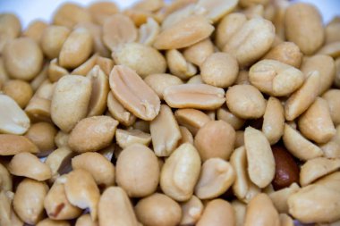 Kavrulmuş tuzlu fıstıklar yakın çekimde, seçici bir odak noktası. Kavrulmuş ve tuzlanmış fıstık dünyanın en popüler çerezlerinden biridir. Kıtır kıtır kıtır dokuları ve yüksek enerji alımlarıyla takdir edilir..