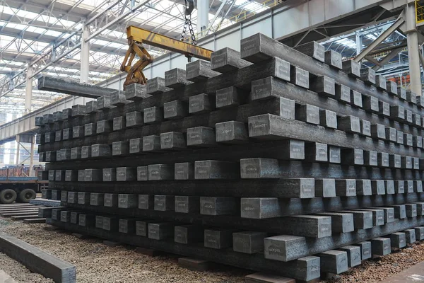 Yüksek sıcaklıkta yuvarlandıktan sonra çelik kirişler düzgünce bir araya toplanır ve soğuk koyu gri metal yüzey endüstriyel oksitlenme rengine sahiptir ki bu da büyük çelik fabrikasının karakteristik özelliğidir.