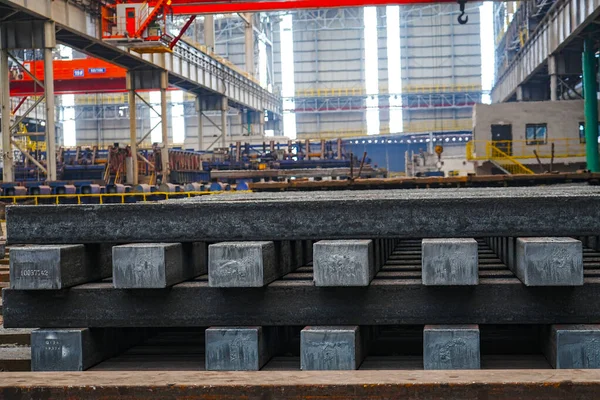 Yüksek sıcaklıkta yuvarlandıktan sonra çelik kirişler düzgünce bir araya toplanır ve soğuk koyu gri metal yüzey endüstriyel oksitlenme rengine sahiptir ki bu da büyük çelik fabrikasının karakteristik özelliğidir.