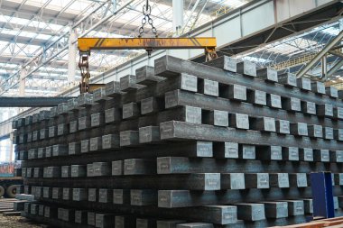 Yüksek sıcaklıkta yuvarlandıktan sonra çelik kirişler düzgünce bir araya toplanır ve soğuk koyu gri metal yüzey endüstriyel oksitlenme rengine sahiptir ki bu da büyük çelik fabrikasının karakteristik özelliğidir.