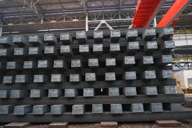 Yüksek sıcaklıkta yuvarlandıktan sonra çelik kirişler düzgünce bir araya toplanır ve soğuk koyu gri metal yüzey endüstriyel oksitlenme rengine sahiptir ki bu da büyük çelik fabrikasının karakteristik özelliğidir.