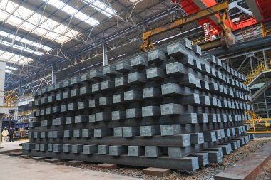 Yüksek sıcaklıkta yuvarlandıktan sonra çelik kirişler düzgünce bir araya toplanır ve soğuk koyu gri metal yüzey endüstriyel oksitlenme rengine sahiptir ki bu da büyük çelik fabrikasının karakteristik özelliğidir.